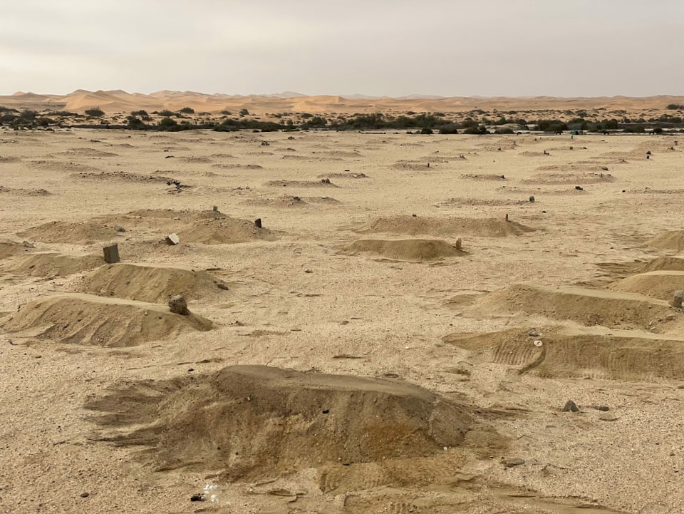 Gräber von Herero und Nama im Sand.