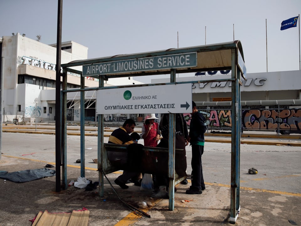 Eine afghanische Familie sitzt in einem alten Limousinen-Stop auf dem Athener Flughafen, der 2001 stillgelegt wurde. 