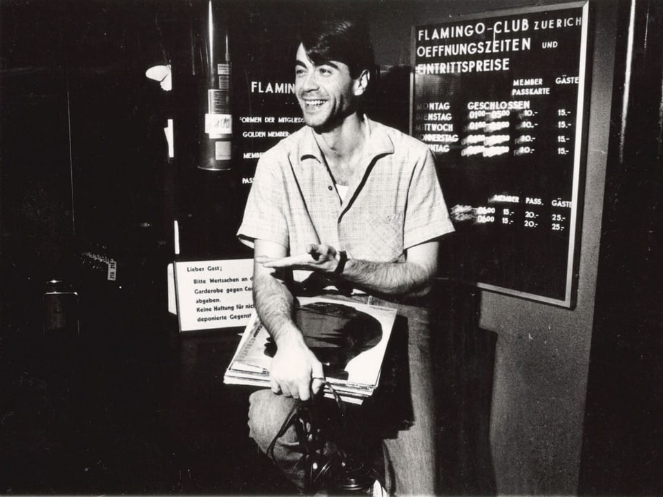 Ein Mann mit Vinyl-Platten in den Händen vor dem Eingang eines Clubs auf einer Aufnahme von 1987.