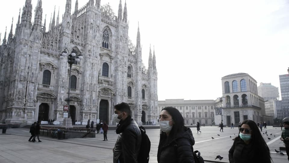 Personen vor dem Dom in Mailand mit Atemschutzmaske.