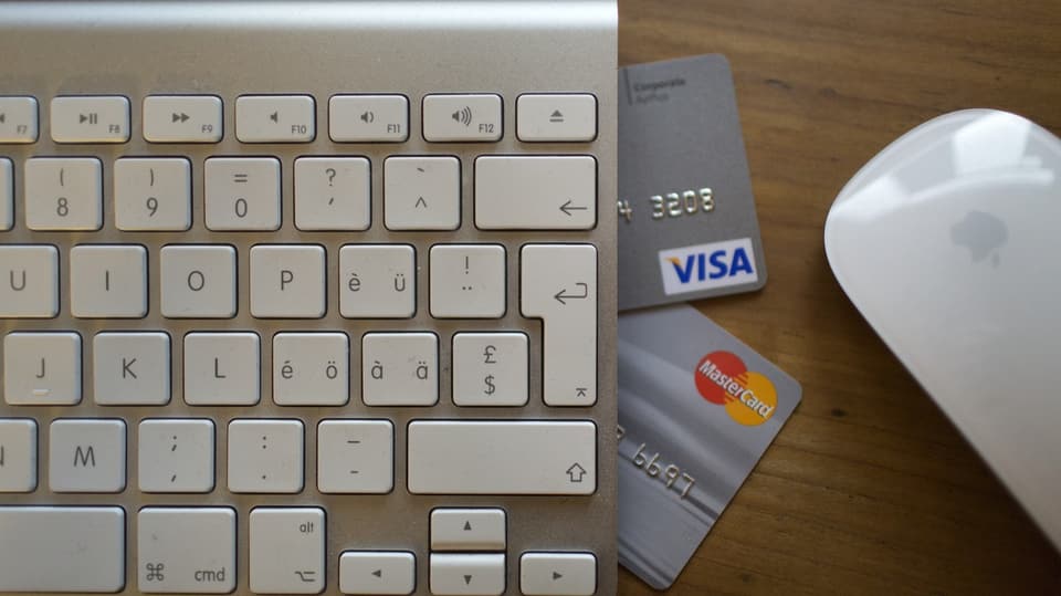 Nahaufnahme von Computer-Tastatur, Maus und zwei Kreditkarten