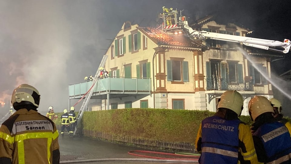 Feuerwehrleute löschen ein brennendes Haus