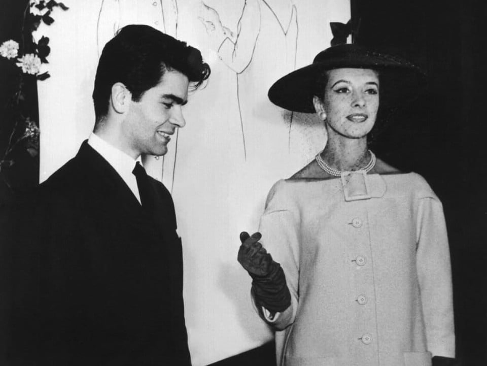 Der junge Karl Lagerfeld führt 1954 ein Model im Cocktailmantel vor.