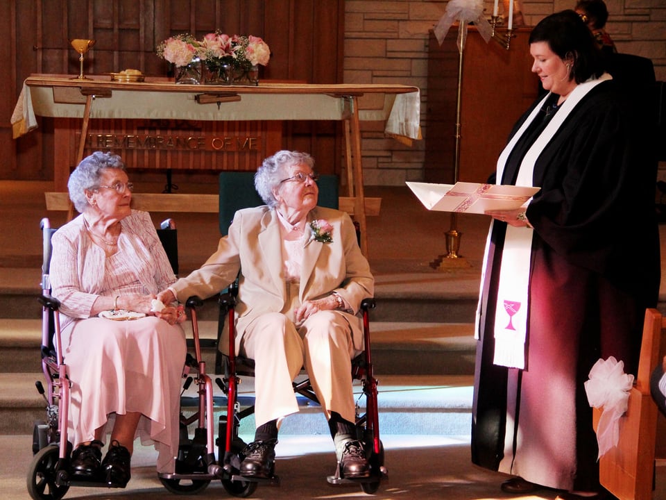 Zwei alte Frauen im Rollstuhl in einer Kirche