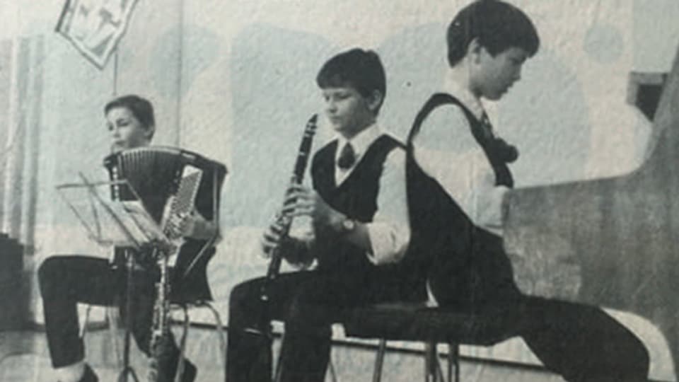 Schwarz-Weiss-Fotografie mit drei jungen Musikanten bei einem Auftritt.