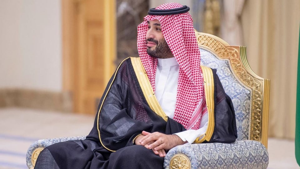 Crown Prince Mohammed bin Salman sits on a chair and smiles