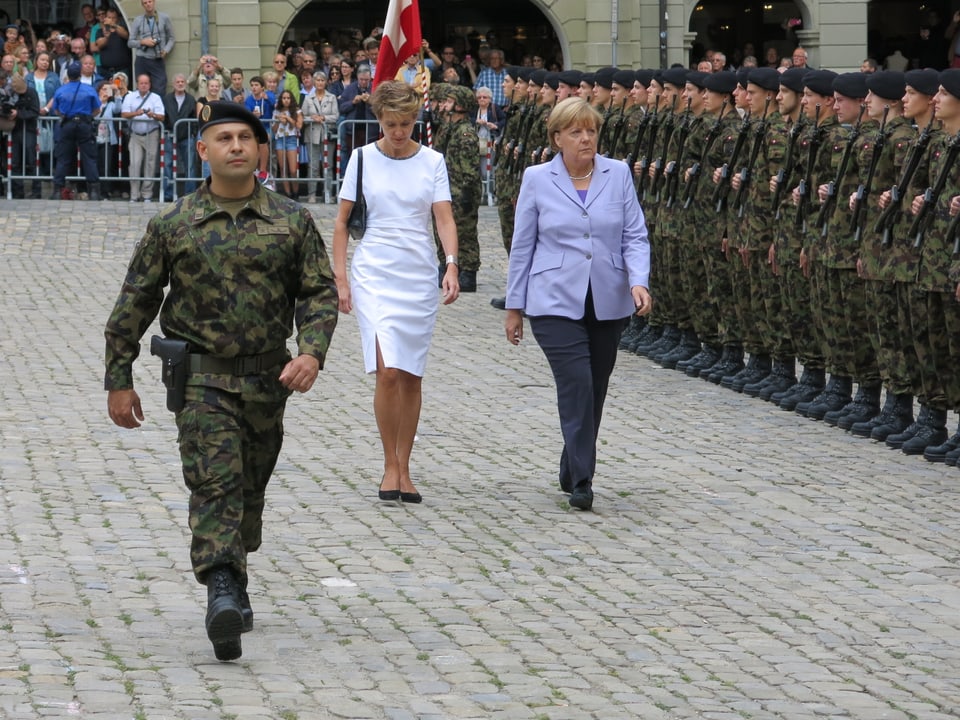 Simonetta Sommaruga schreitet mit Angela Merkel die Ehrenkompanie ab. 