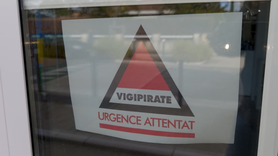 Vigipirate Alerte Attentat-Logo klebt an einer Fensterfassade.