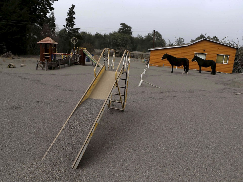 Die Rutschbahn auf einem Spielplatz ist mit einer Ascheschicht bedeckt. 