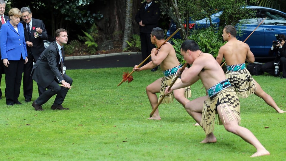 Angela Merkel beobachtet eine Maori Tanzzeremonie. 