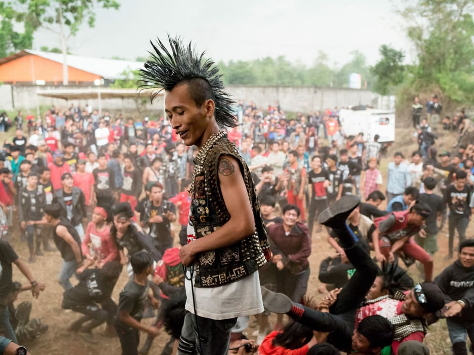 Der Musiker einer Punkband in Indonesien steht auf der Bühne vor grossem Publikum