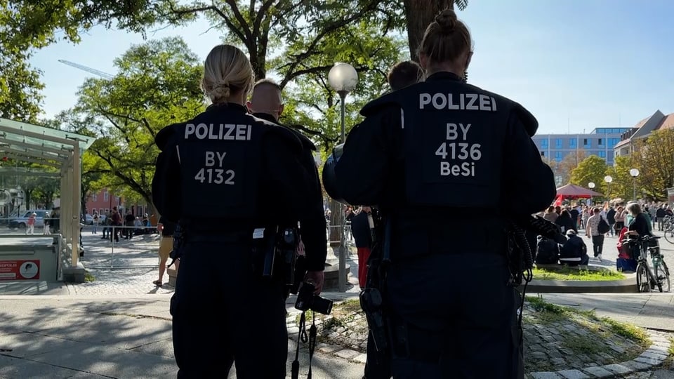 Zwei Polizistinnen stehen mit dem Rücken zur Kamera auf der Wahlveranstaltung in Ingolstadt.