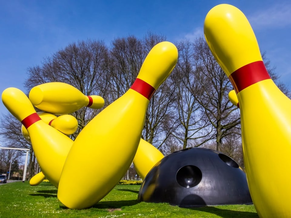 Skulptur überdimensionierter gelber Kegel mit halbem Bowling-Ball