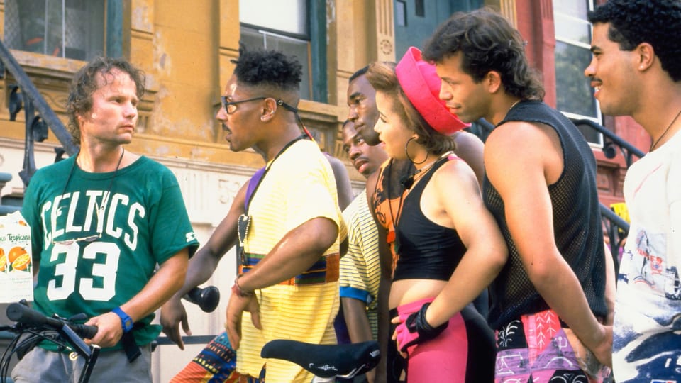 Filmszene: Ein weisser Mann im Gespräch mit einer Gruppe afroamerikanischer Männer und Frauen.