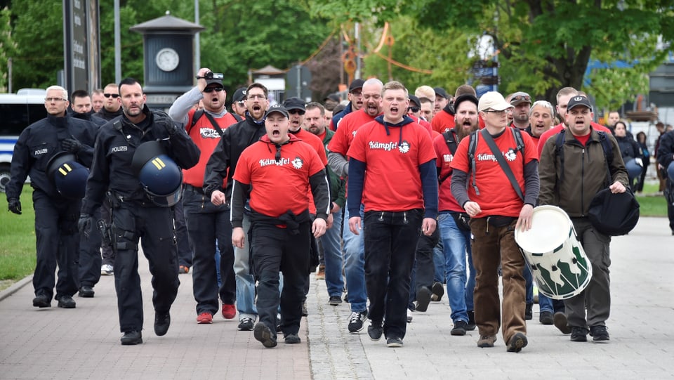 Ein Gruppe von rechtsextremen Demonstranten mit roten T-Shirts.