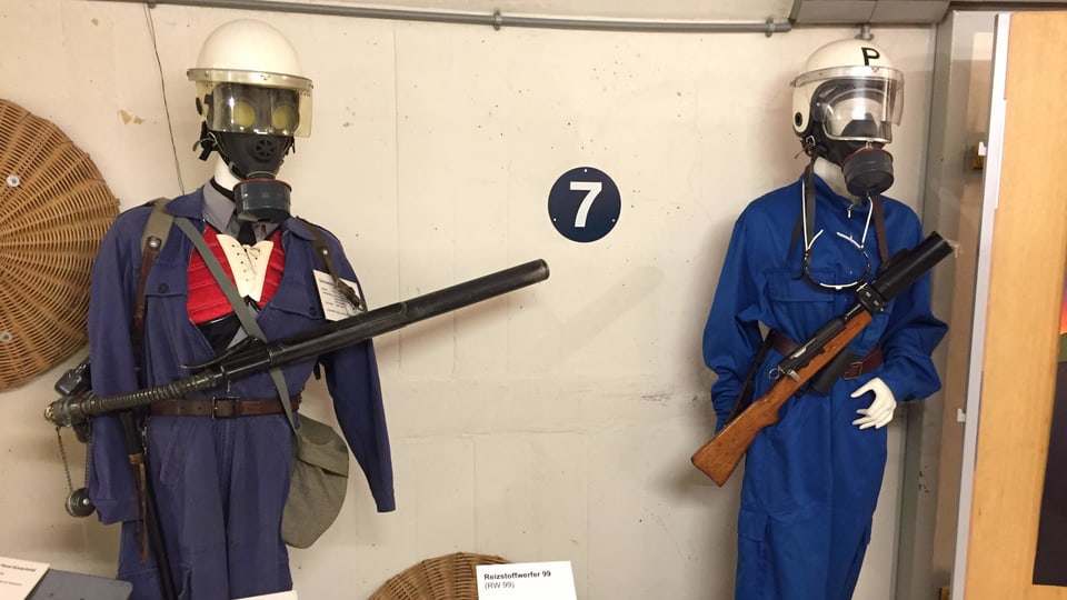 Zwei Polizeipuppen mit ältlich wirkenden, blauen Unifromen sind ausgestellt in einem Museum.