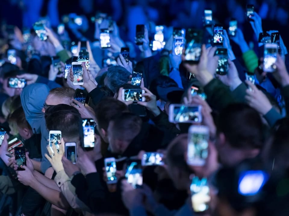Jugendliche halten Handys an Konzert hochh