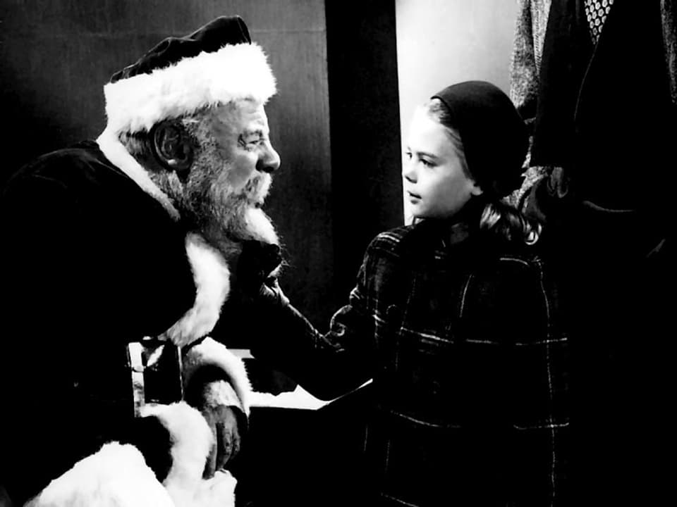 Weihnachtsmann und kleines Mädchen sehen sich an. Bild in schwarzweiss.