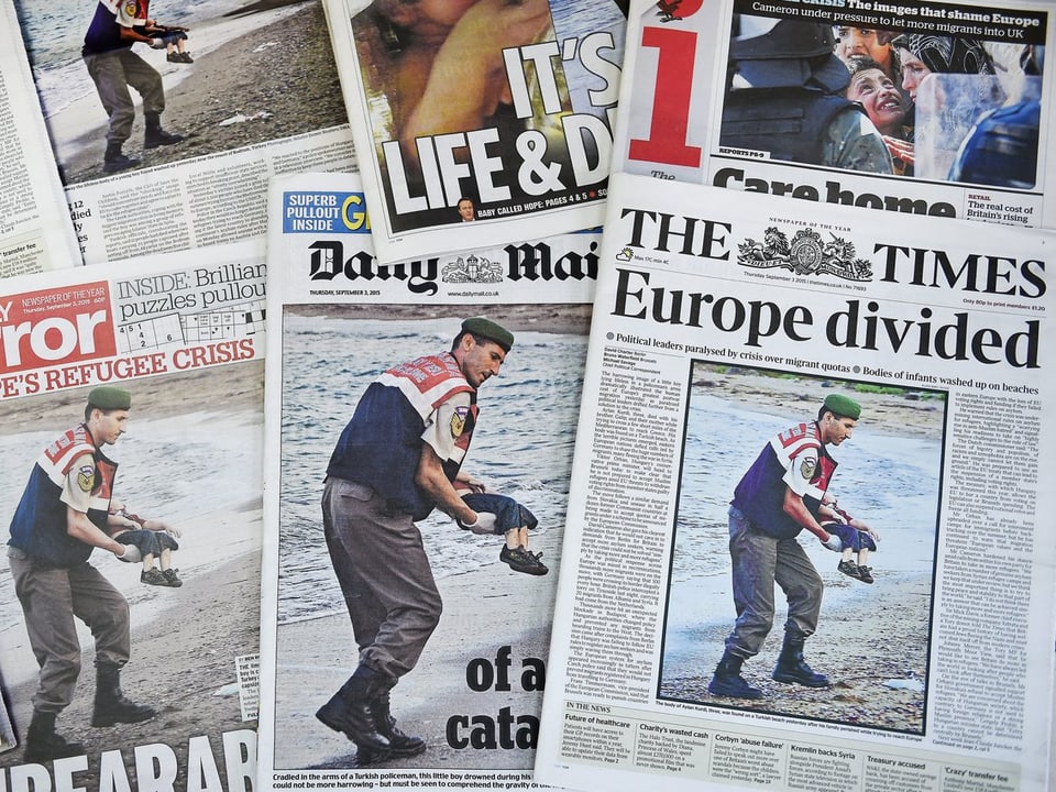 Ein Stapel an Tageszeitungen aus aller Welt, die das Bild des toten Junge auf der Frontseite haben.