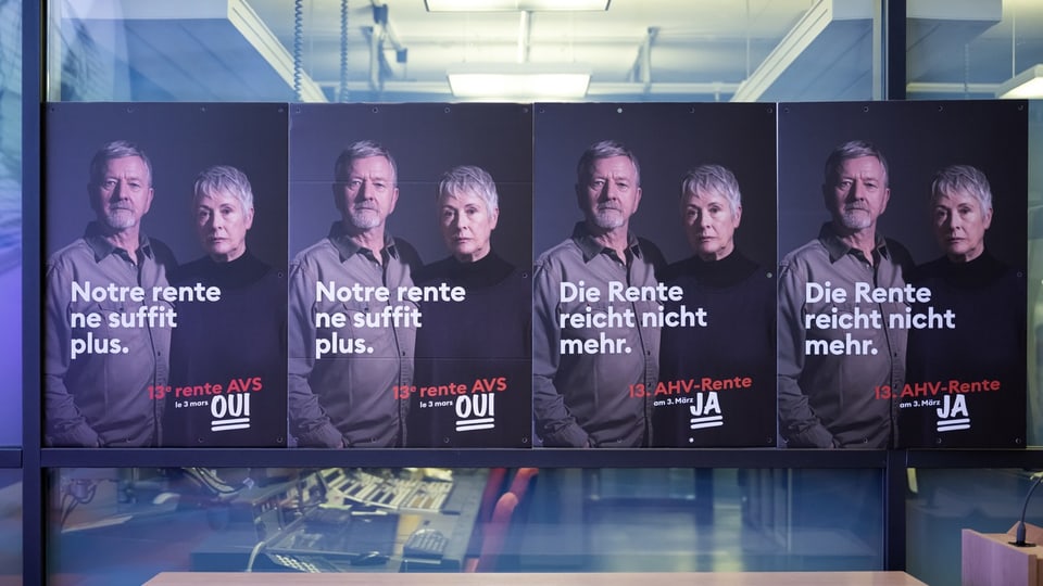 Mehrere Plakate der Ja-Kampagne mit der Aufschrift «Die Rente reicht nicht mehr» hängen nebeneinander an einer Glaswand