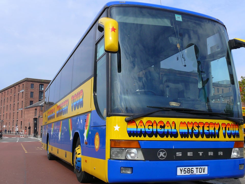 Ein gelb-blau lackierte Bus mit der Aufschrift: Magical Mystery Tour.