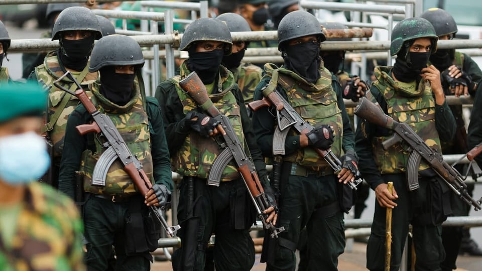Soldaten in Sri Lanka stehen in Uniform und mit Sturmgewehren nebeneinander.