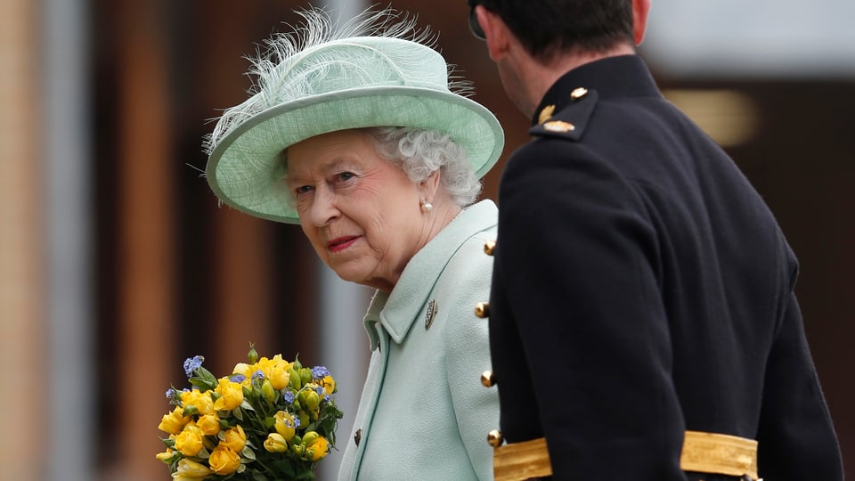 Königin Elisabeth II. mit einem Blumenstrauss in der Hand.