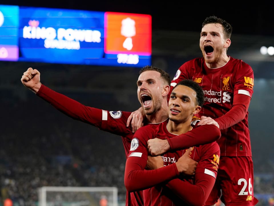 3 Liverpool-Spieler jubeln gemeinsam, indem sie in die Höhe springen.