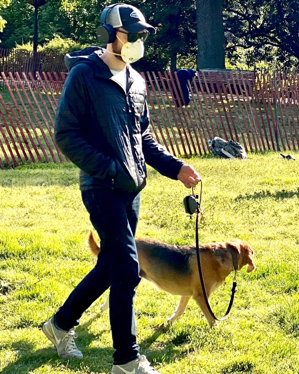 Im «Malcom X Park» führt ein Mann seinen Hund Gassi. Er trägt eine Maske.