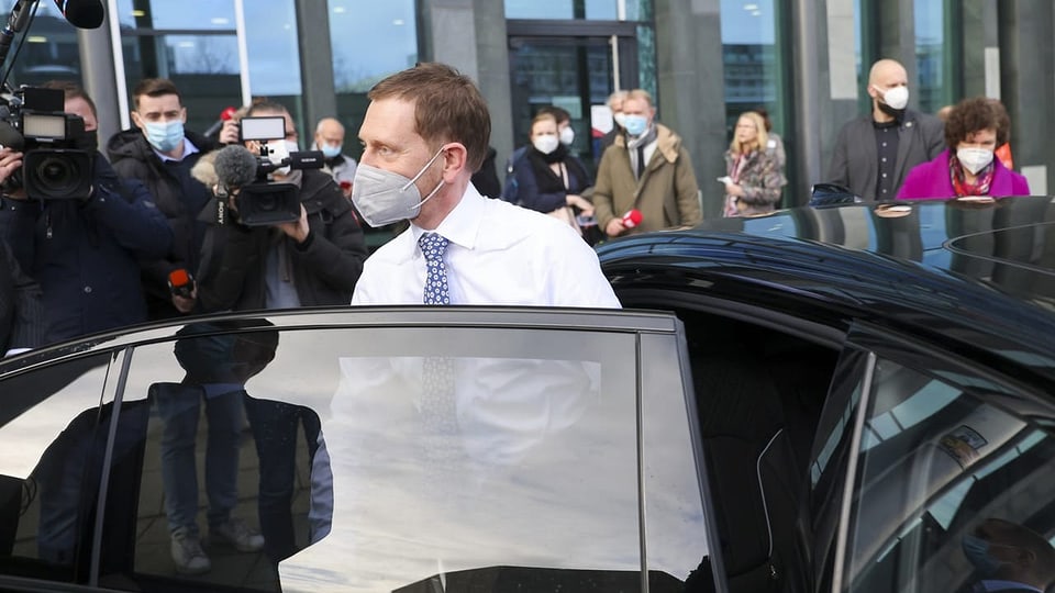 Michael Kretschmer steigt aus einem Auto aus, im Hintergrund sind Journalisten