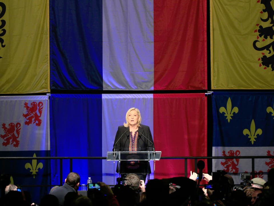 Marine Le Pen, an einer Rede vor Frankreichflaggen.