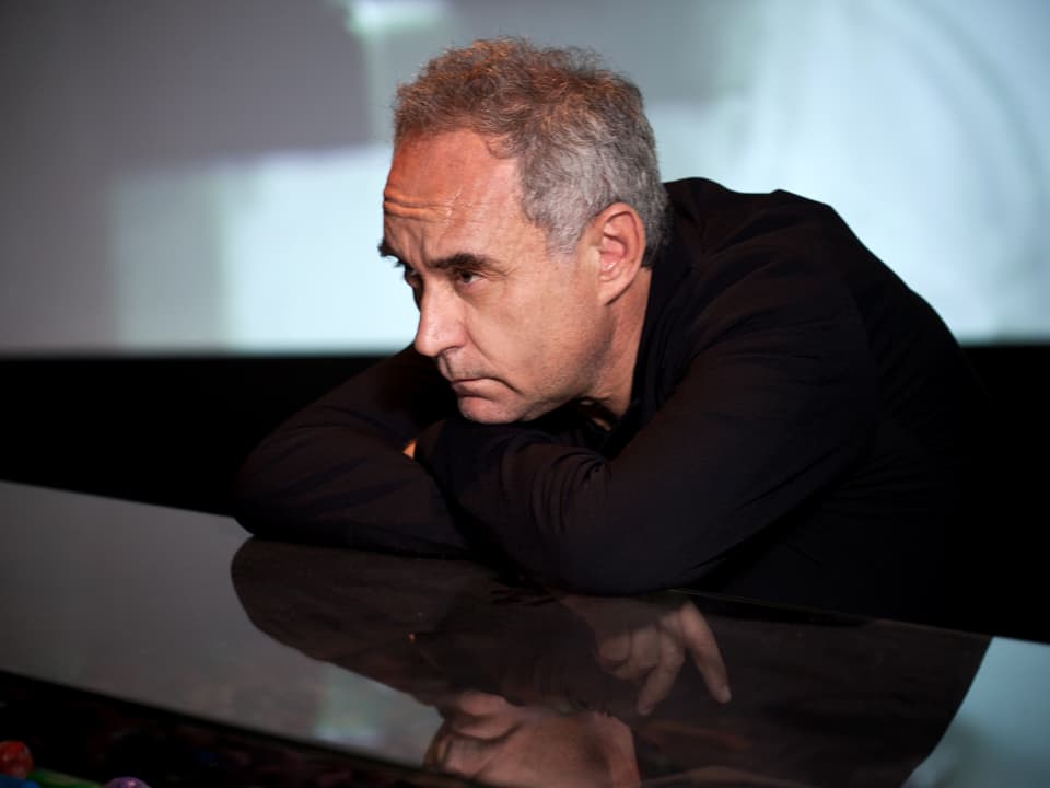 Ferran Adriá, auf einen glänzenden Tresen gelehnt, nachdenklich zur Seite blickend.