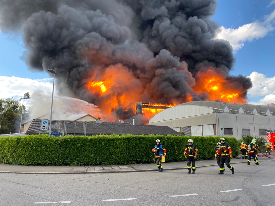 Firefighters, in the background fire and black smoke