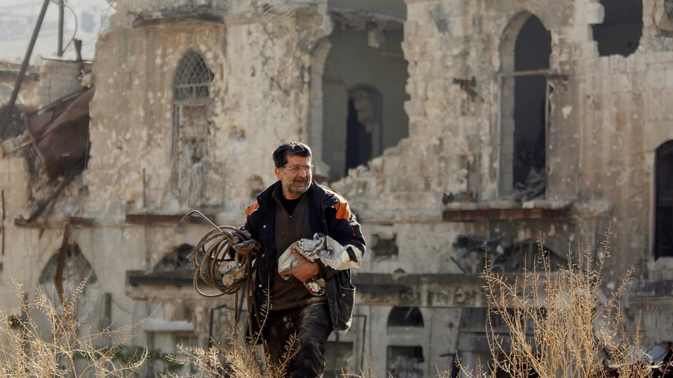 Zu sehen ist ein Mann in den Ruinen von Aleppo.