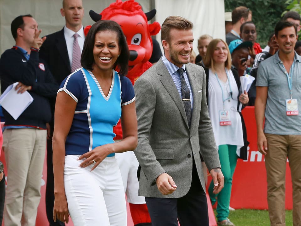 Michelle Obama (links) lachend neben David Beckham (rechts)