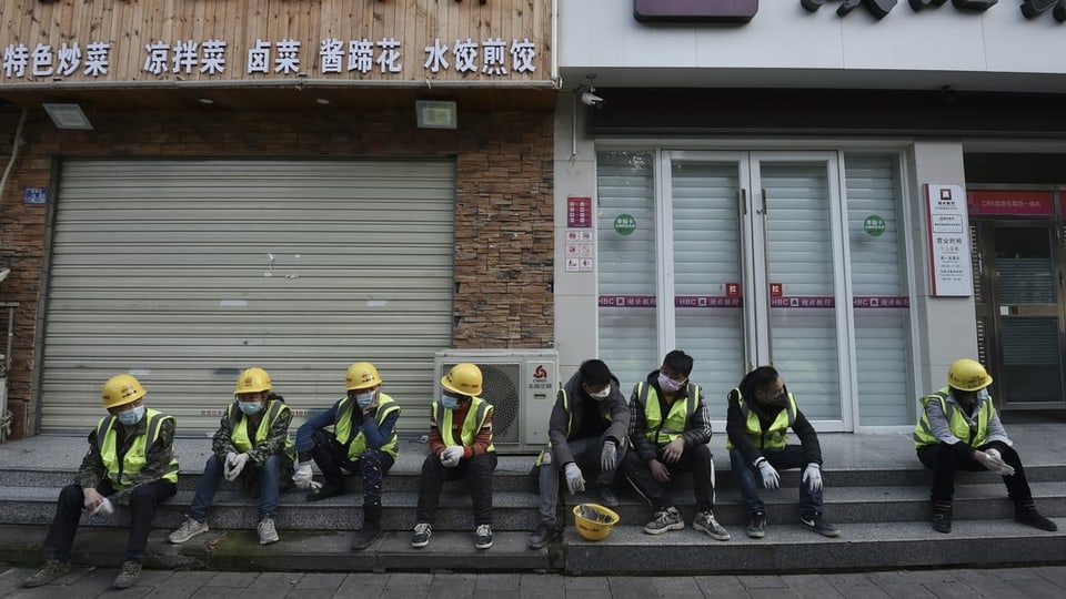 Arbeiter in der Provinz Hubei machen Pause vor geschlossenen Restaurants.