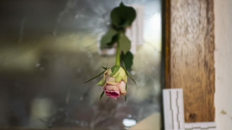 Eine Rose wurde in Gedenken an die Opfer in ein Einschussloch gesteckt.