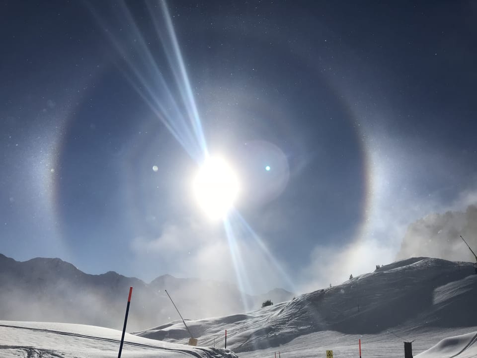 Ein Halo, ein optisches Phänomen durch Brechung der Sonnenstrahlen an Eiskristallen entstanden, zeigt sich über dem Skigebiet.