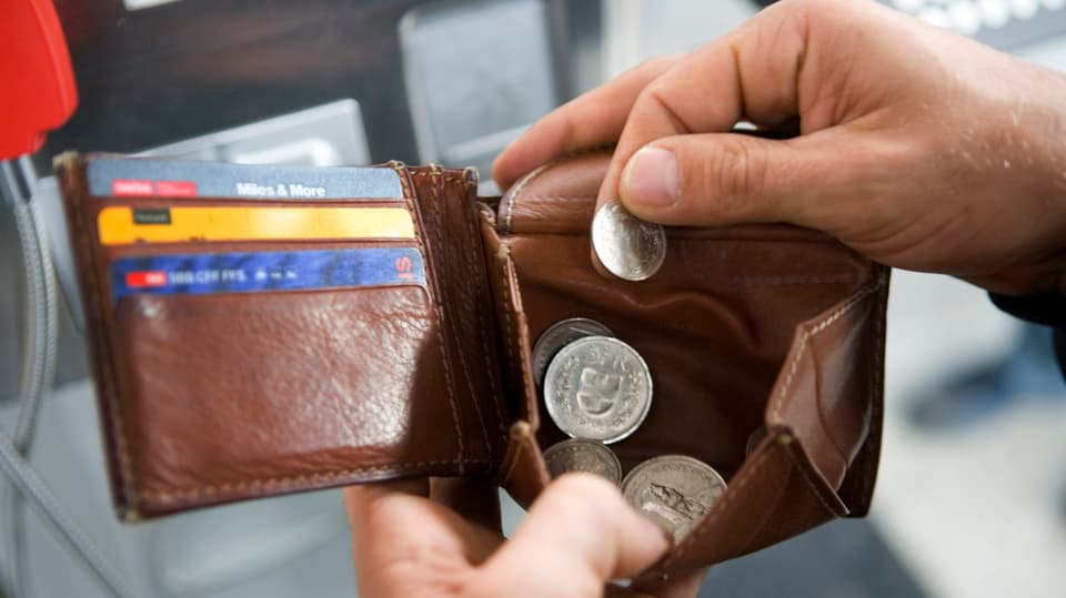 Eine Person hält ein Portemonnaie in den Händen.