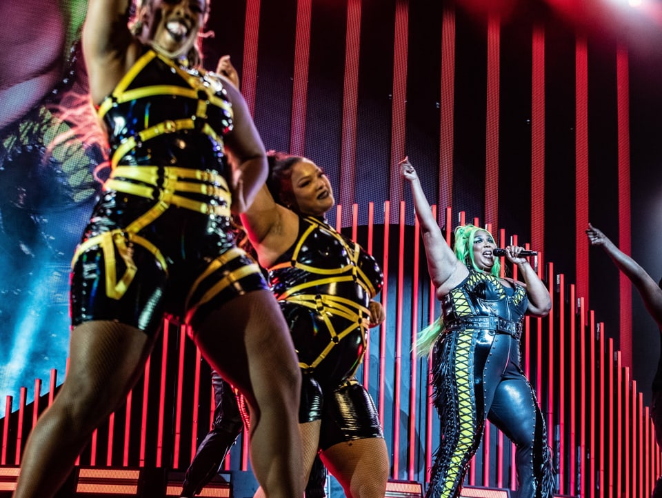 Drei afroamerikanische Frauen tanzen und singen auf einer Bühne