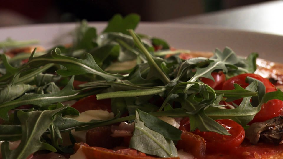 Pizza mit Ruccola und Tomaten