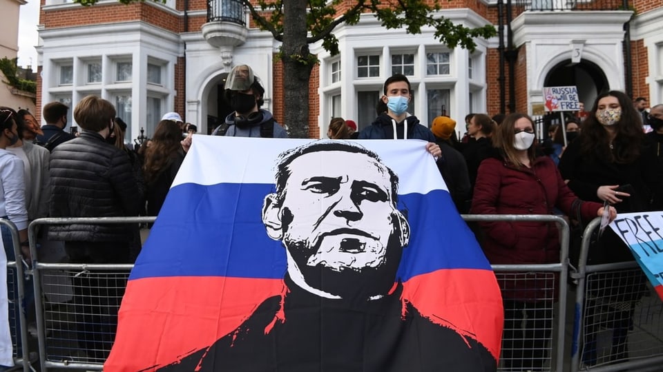 Demonstranten mit einer Flagge mit Nawalny drauf.