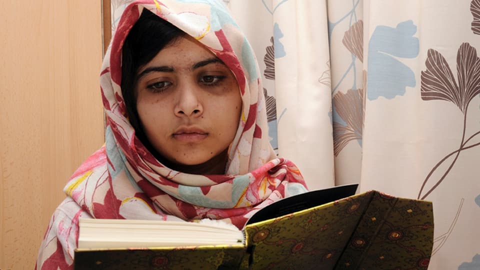 Die pakistanische Kinderrechtsaktivistin Malala Yousafzai liest in einem Buch.