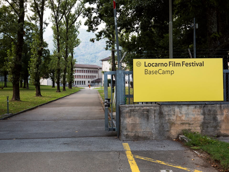 Einfahrt zur Kaseren, daneben ein grosses gelbes Schild mit der Aufschrift "Locarno Film festival - Basecamp"