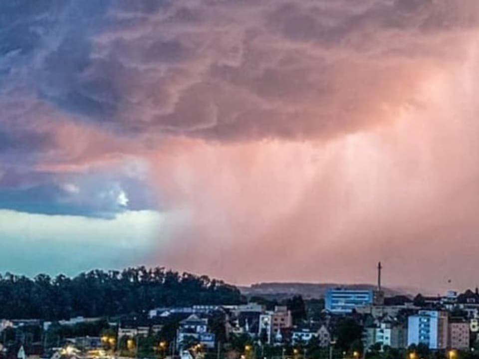 Gewitterwolke mit Regenvorhang über Stadt. 