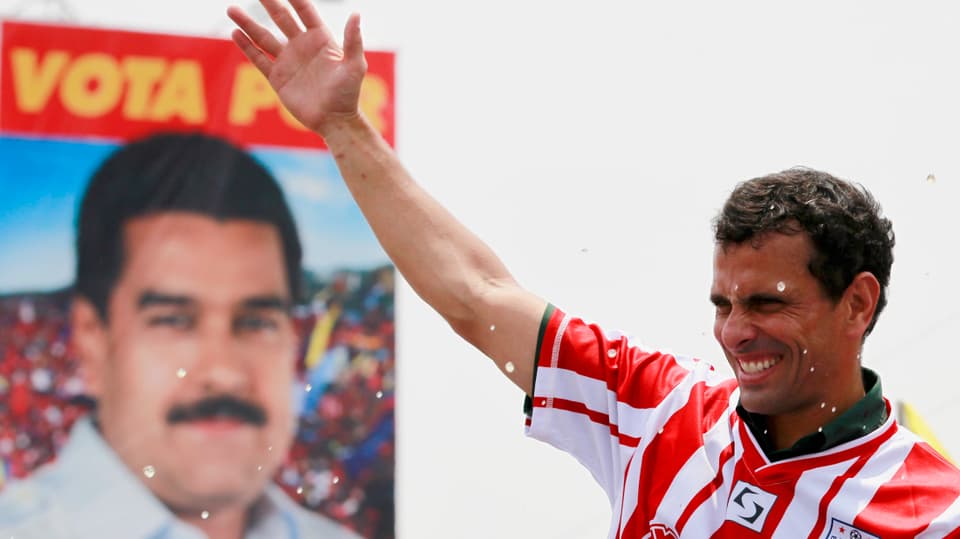Henrique Capriles winkt vor einem Plakat von Nicolas Maduro