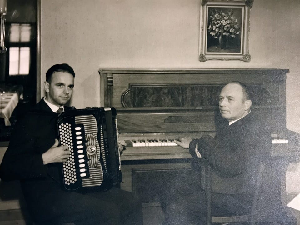 Schwarz-Weiss-Fotografie von einem Akkordeonisten und einem Pianisten.