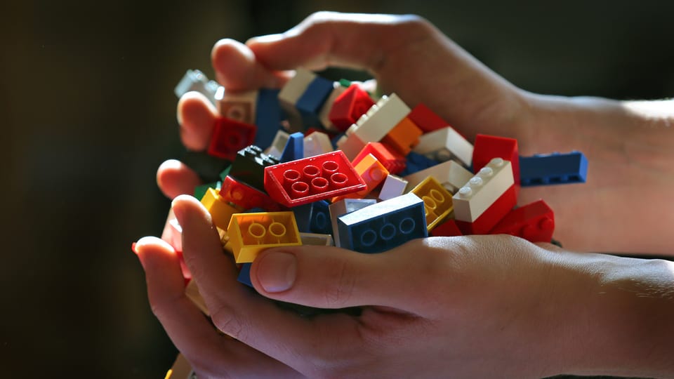Eine Hand voll mit Lego-Steinen.