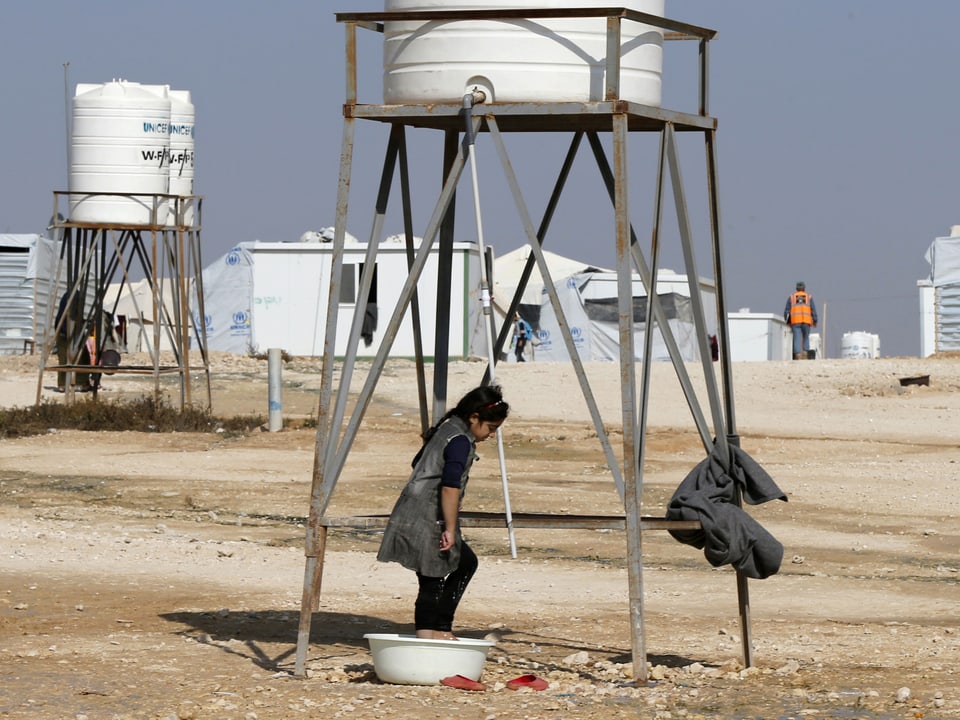 Ein syrisches Flüchtlingsmädchen wäscht Wäsche in einem Flüchtlingslager.