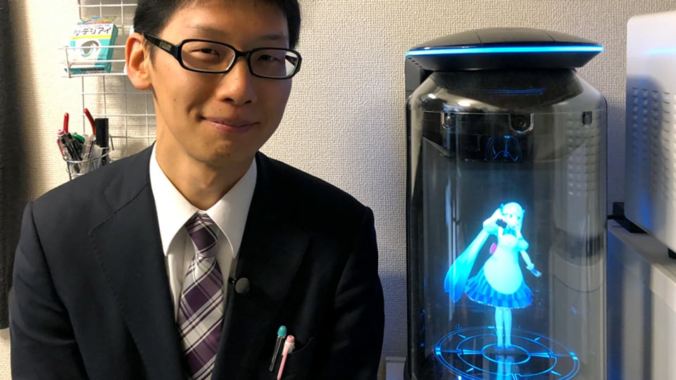 Ein Mann steht neben einem Hologramm.